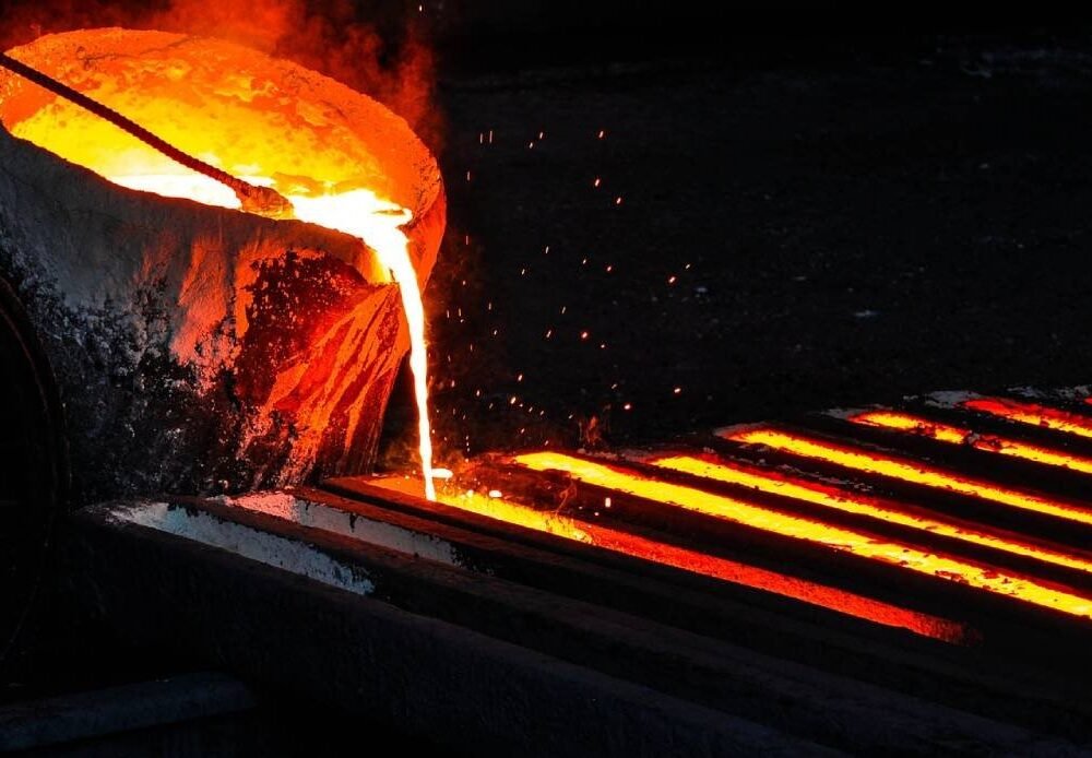 Proses penuangan baja cair ke cetakan ingot di pabrik peleburan baja